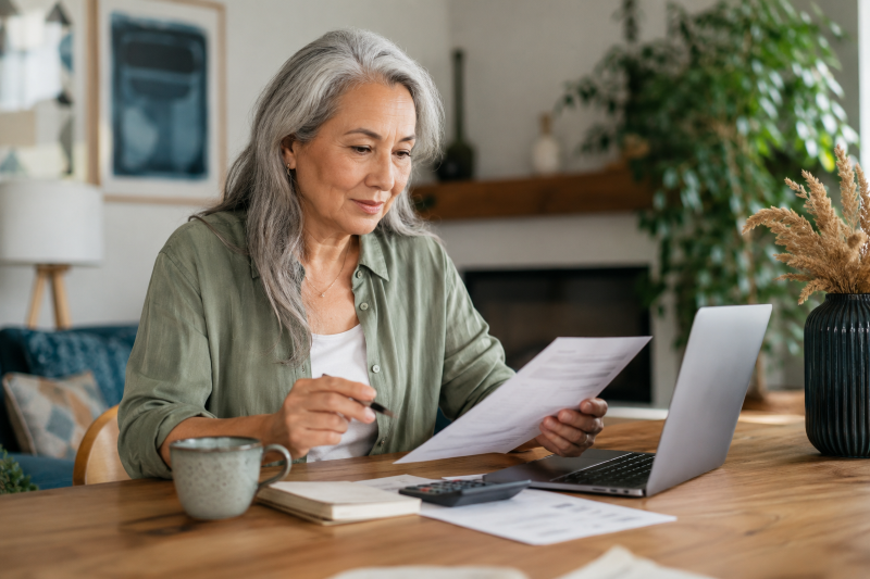 Older woman reviewing retirement paperwork at home for Can Equity Release Support Retirement Income article